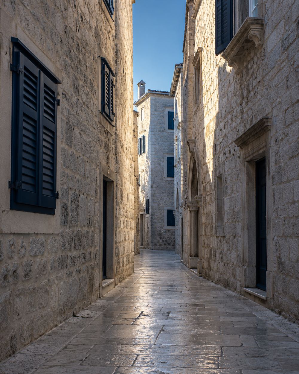 A narrow limestone street in an old Dalmatian town in morning light